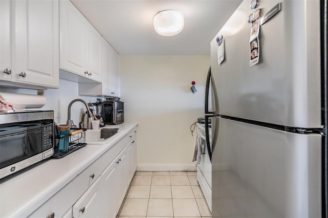 kitchen featuring white cabinetry, appliances with stainless steel finishes, sink, and light tile patterned floors