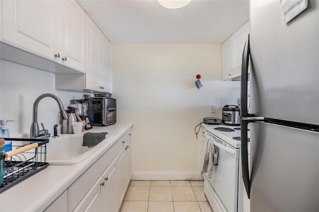 kitchen featuring white electric stove, white cabinetry, sink, and stainless steel refrigerator