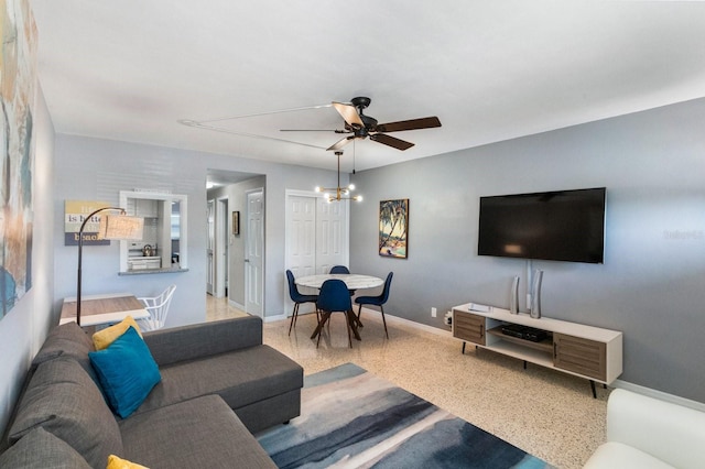 living room featuring ceiling fan with notable chandelier