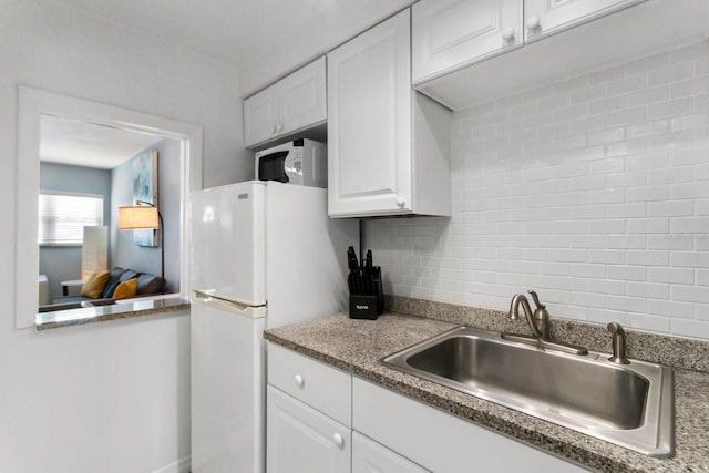 kitchen featuring white appliances, sink, decorative backsplash, and white cabinets