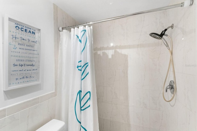 bathroom featuring curtained shower and toilet