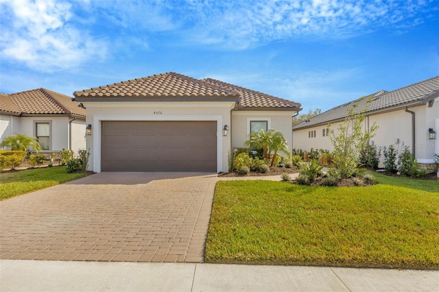 mediterranean / spanish-style home featuring a garage and a front yard