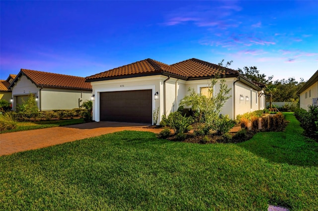 mediterranean / spanish-style house featuring a yard and a garage