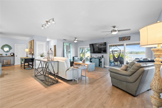 living room featuring ceiling fan and light hardwood / wood-style flooring