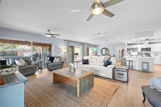 living room featuring ceiling fan and light hardwood / wood-style floors