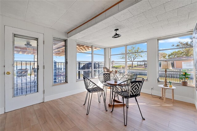 sunroom featuring a water view and a wealth of natural light