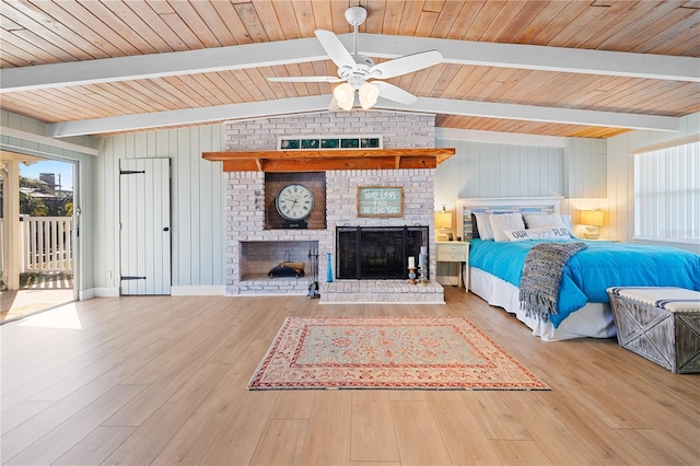 unfurnished bedroom with a brick fireplace, access to outside, hardwood / wood-style floors, and lofted ceiling with beams