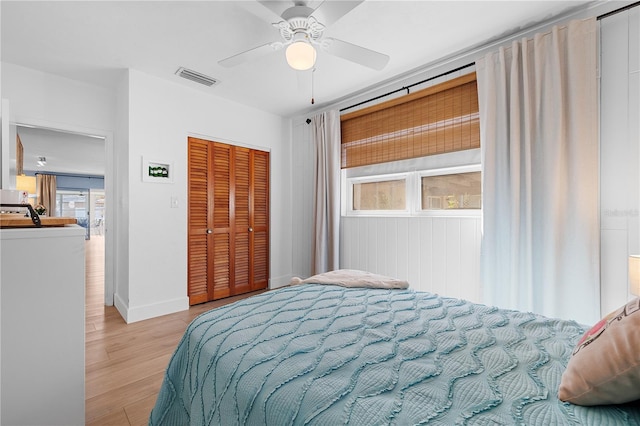 bedroom with ceiling fan, a closet, light hardwood / wood-style floors, and multiple windows