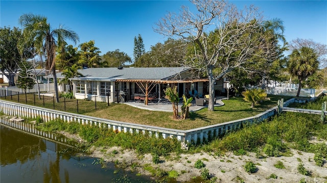 rear view of house with a yard, a patio, and a water view