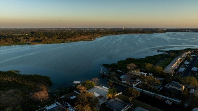 aerial view at dusk featuring a water view