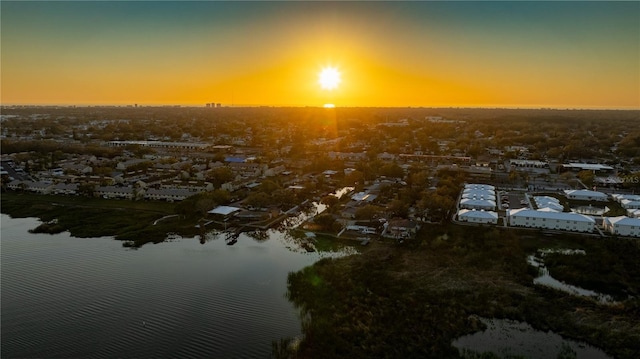 aerial view at dusk featuring a water view