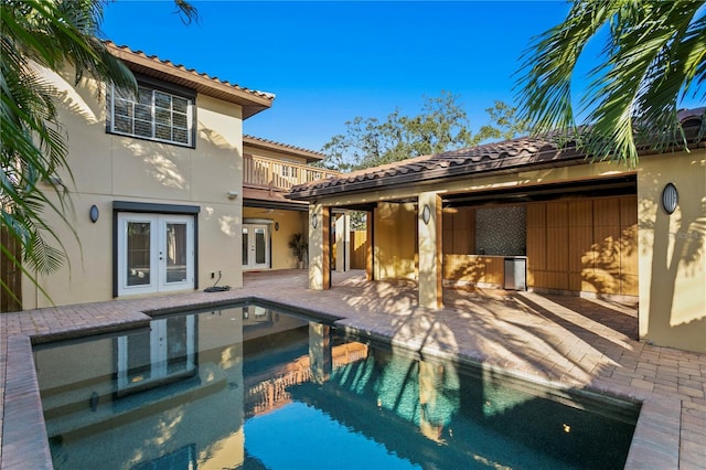 view of swimming pool with french doors and a patio area