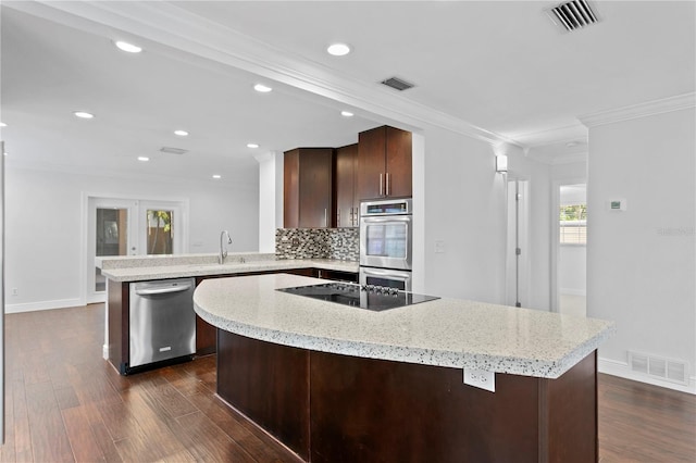 kitchen with stainless steel appliances, dark hardwood / wood-style floors, tasteful backsplash, ornamental molding, and kitchen peninsula