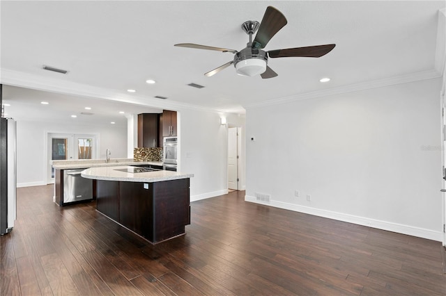 kitchen featuring dark brown cabinetry, appliances with stainless steel finishes, dark hardwood / wood-style floors, and kitchen peninsula