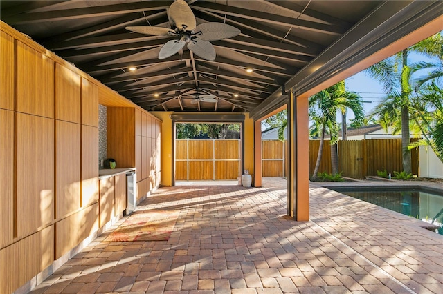 view of patio / terrace with a fenced in pool, beverage cooler, and ceiling fan