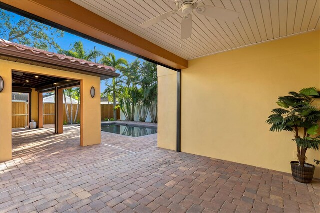 view of patio featuring ceiling fan and a fenced in pool