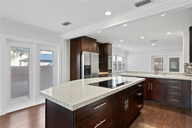 kitchen featuring sink, a center island, stainless steel fridge with ice dispenser, crown molding, and black electric cooktop