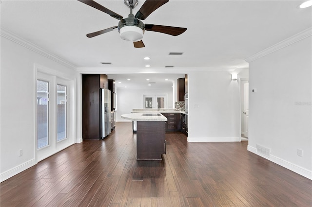 kitchen with crown molding, dark brown cabinets, stainless steel fridge, dark hardwood / wood-style floors, and decorative backsplash