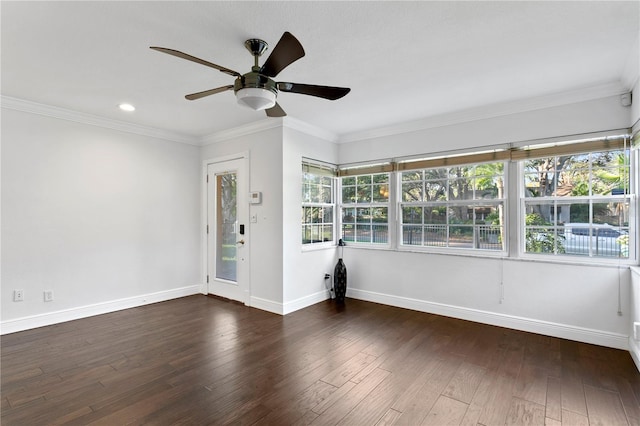 empty room featuring dark hardwood / wood-style flooring, crown molding, and ceiling fan