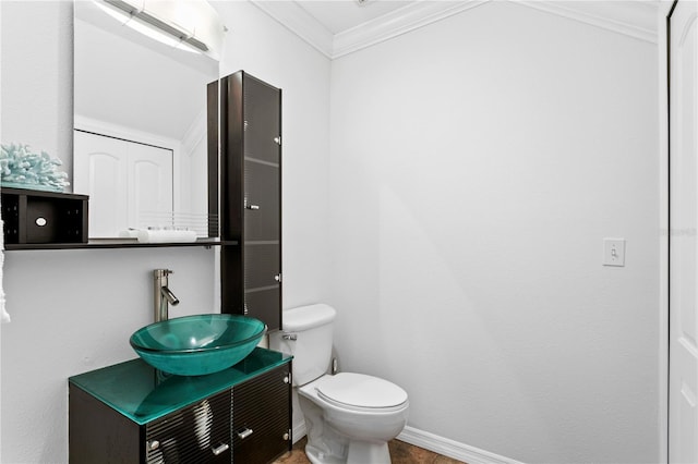 bathroom with ornamental molding, toilet, and vanity