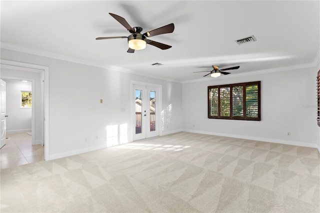 carpeted spare room with crown molding, plenty of natural light, and french doors