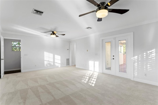 carpeted spare room with french doors, ceiling fan, and ornamental molding