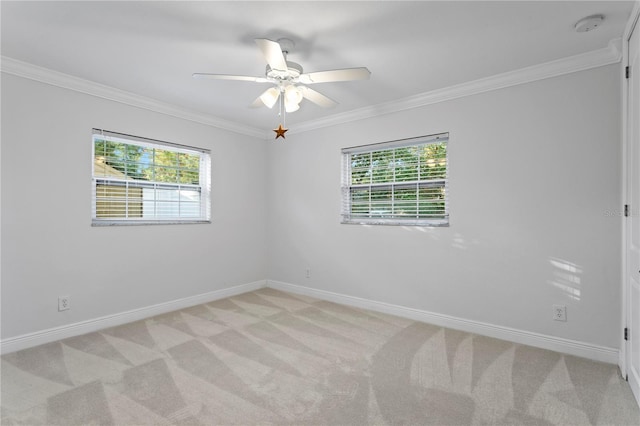 spare room featuring a wealth of natural light, ornamental molding, light colored carpet, and ceiling fan