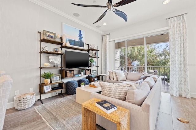 living room featuring crown molding, ceiling fan, and light hardwood / wood-style flooring