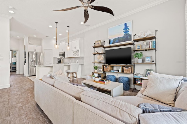 living room featuring crown molding, ceiling fan, and light wood-type flooring