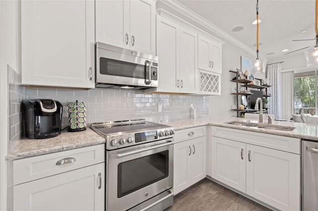 kitchen with pendant lighting, sink, white cabinets, stainless steel appliances, and crown molding