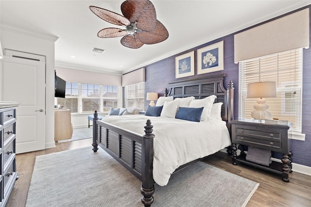 bedroom with crown molding, wood-type flooring, and ceiling fan