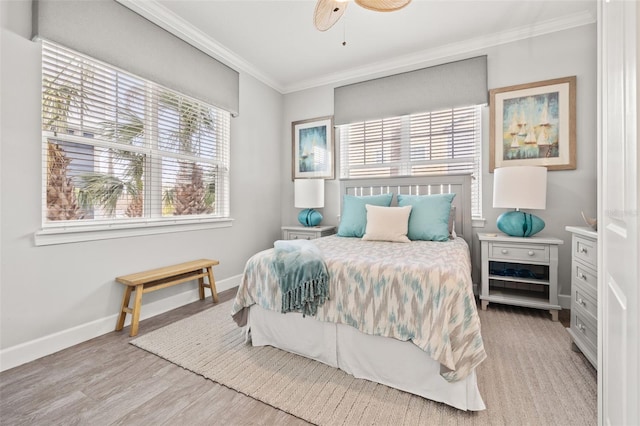 bedroom featuring multiple windows, ornamental molding, and light wood-type flooring