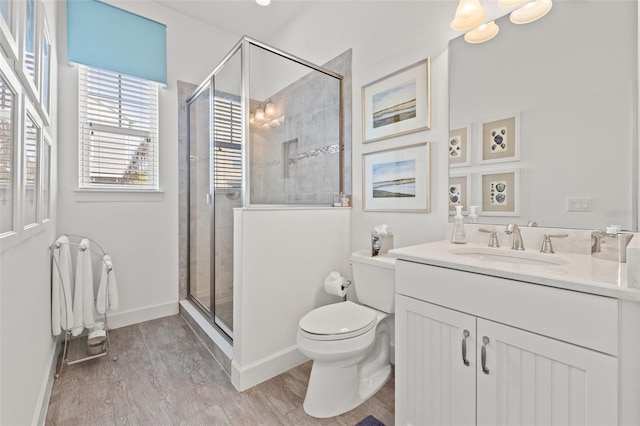 bathroom featuring an enclosed shower, vanity, wood-type flooring, and toilet