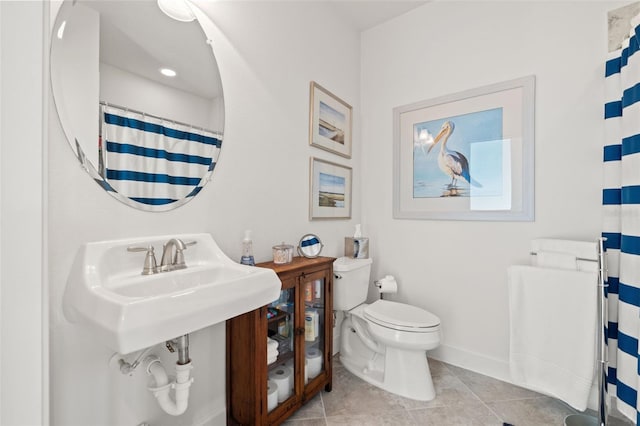 bathroom featuring a shower with shower curtain, tile patterned floors, and toilet