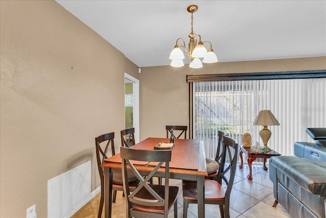 dining space featuring light tile patterned floors and a chandelier