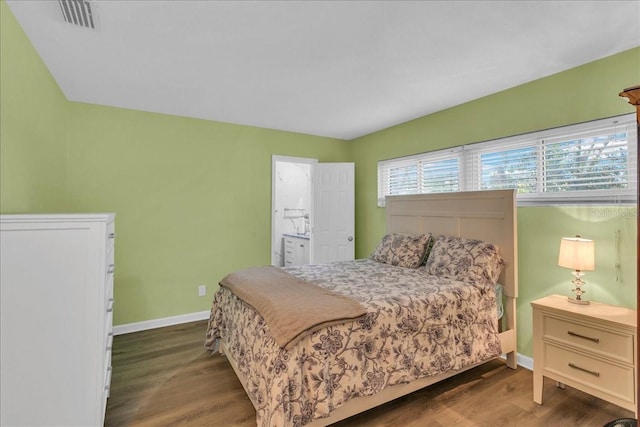 bedroom featuring hardwood / wood-style floors and ensuite bathroom