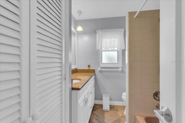 full bathroom featuring tile patterned flooring, vanity, tiled shower / bath, and toilet