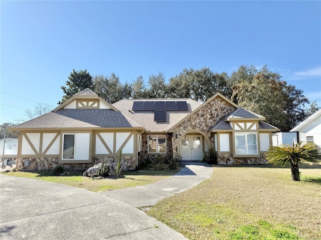 tudor-style house with a front lawn and solar panels