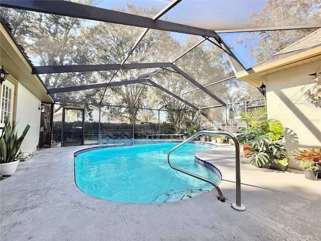 view of swimming pool featuring a patio and glass enclosure