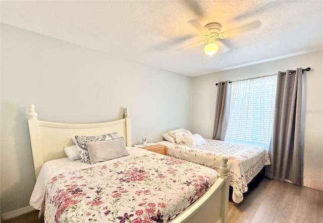 bedroom featuring wood-type flooring, ceiling fan, and a textured ceiling