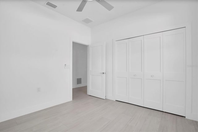 unfurnished bedroom featuring ceiling fan, light hardwood / wood-style floors, and a closet