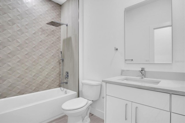 full bathroom featuring tiled shower / bath, vanity, and toilet