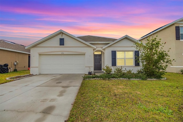 ranch-style home with a garage and a lawn