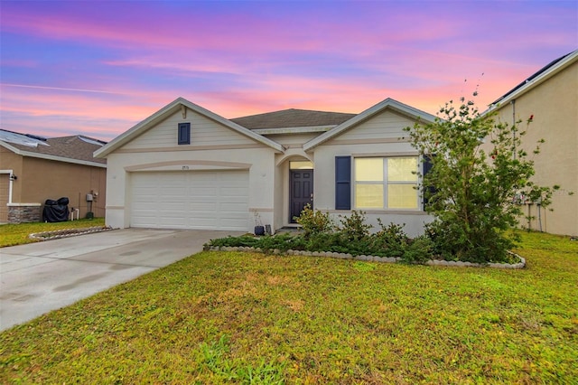 ranch-style house featuring a garage and a lawn