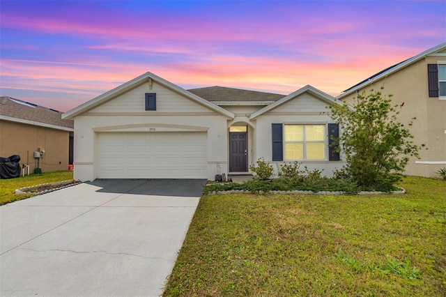 ranch-style house with a garage, stucco siding, concrete driveway, and a front lawn