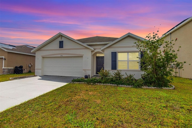 ranch-style home with stucco siding, an attached garage, concrete driveway, and a front yard