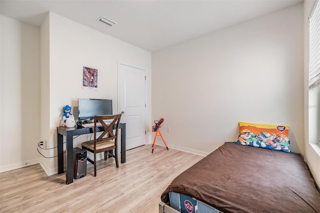 bedroom featuring visible vents, baseboards, and light wood finished floors