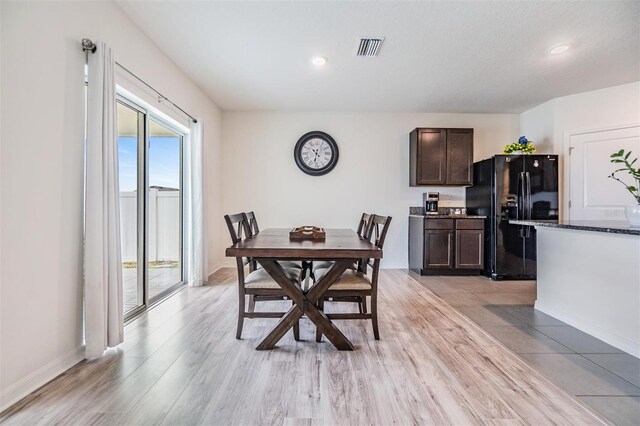 dining area featuring visible vents, baseboards, and light wood-style floors