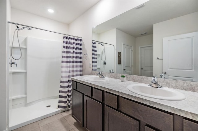 bathroom featuring tile patterned flooring, a shower stall, and a sink