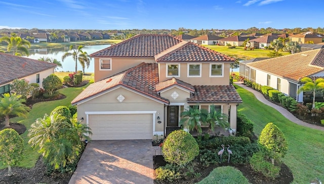 mediterranean / spanish home featuring a garage, a front lawn, and a water view